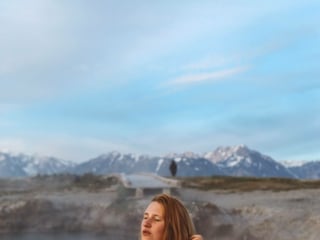 woman in a rainbow swimsuit in a hot spring in the mountains