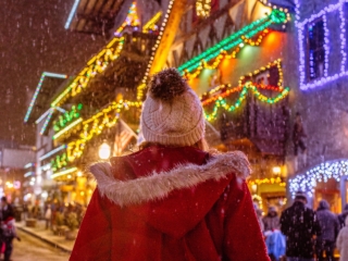 Woman walking down string light lined street