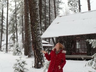 Woman in red coat at snowy Sleeping Lady Resort
