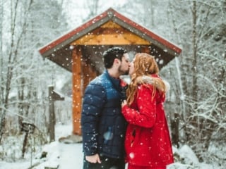Man and Woman kissing in the snow at Sleeping Lady resort