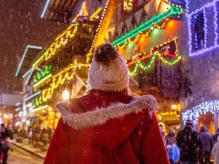woman walking down string light lined street