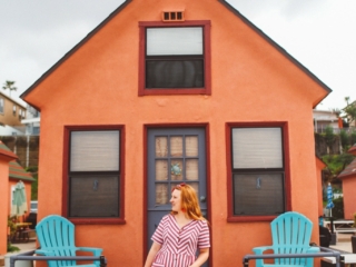 Woman standing in front of one of the Orange Beach rentals in Oceanside, Ca