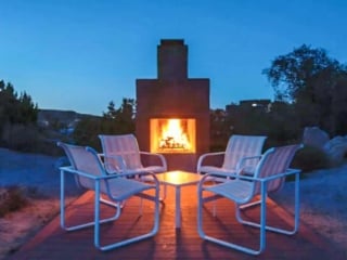 A patio with table and and chairs and a brick fireplace!