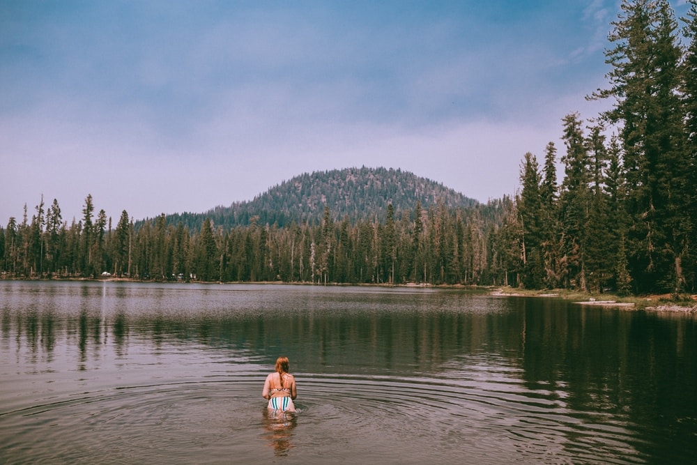 Summit lake surrounded by trees in Lassen Volcanic National Park and mountains