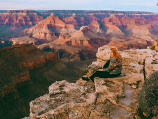 Kara of Whimsy Soul sitting on the edge of the Grand Canyon in Arizona