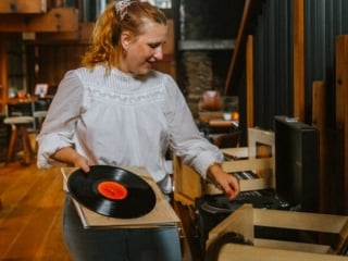 California travel blogger Kara Harms sits in the lobby of Timber Cove Resort wearing a white shirt and jeans